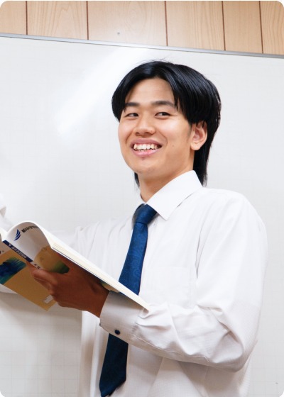 教科書を手に笑顔で立つ代表の沖田祐和