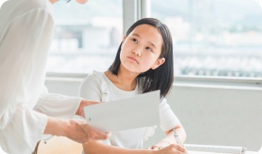 窓際の席で講師の説明を聞く女子生徒