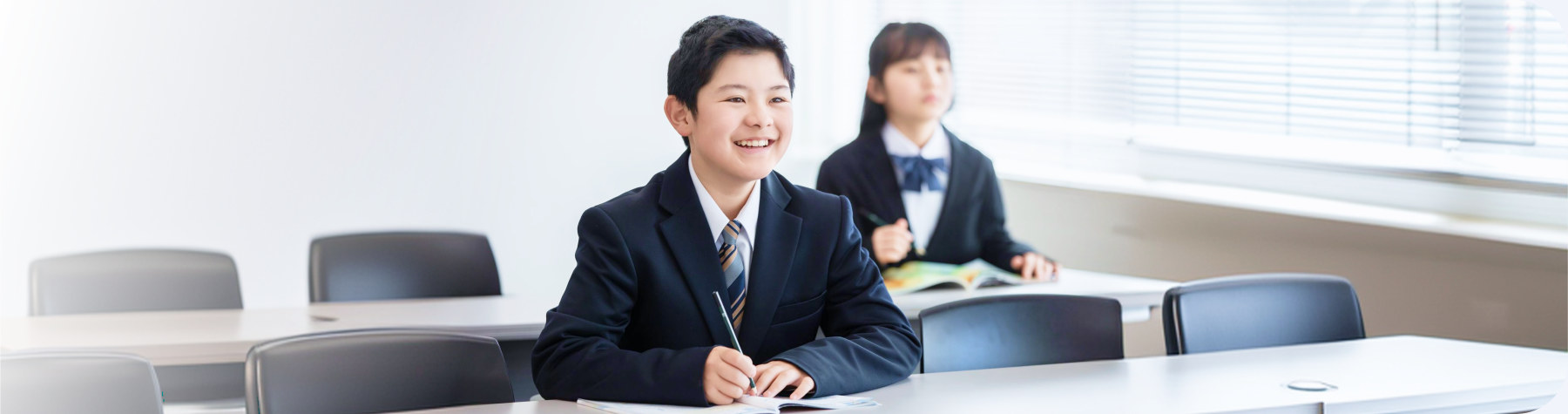 明るい教室の机で笑顔でノートに書き込む制服姿の生徒たち